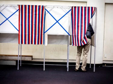 Some standing in a voting booth