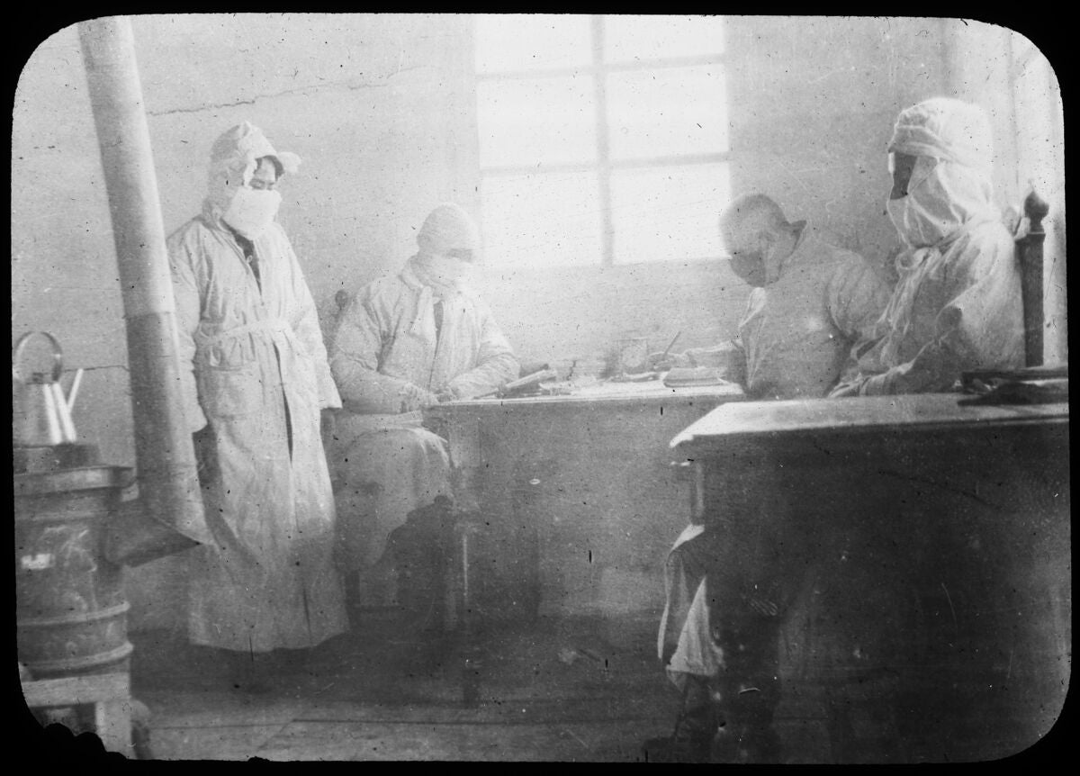 A black and white photo of people in 1911 in masks and protective gear