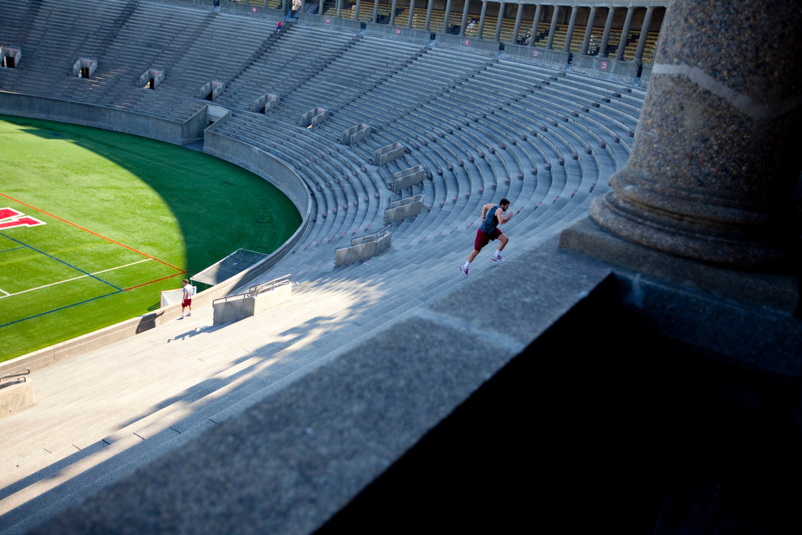 A man running up the steps in Harvard stadium